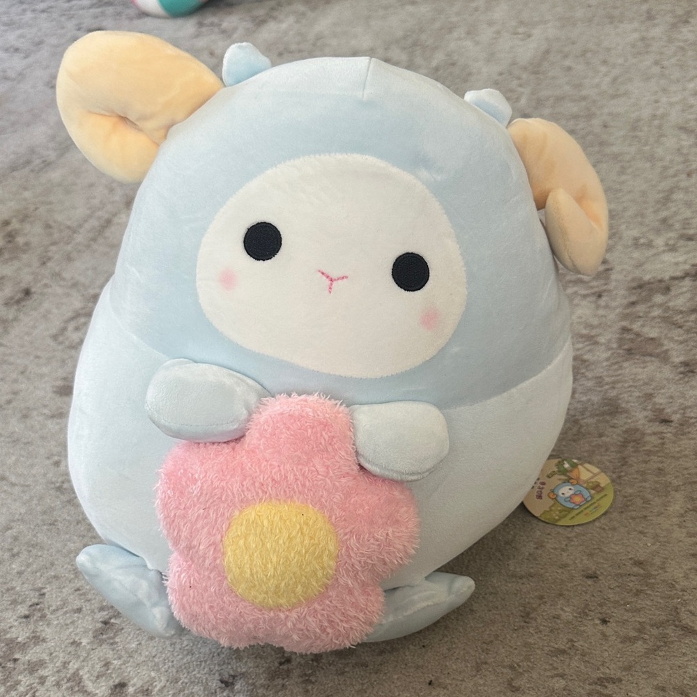 Adorable blue sheep plush holding flower